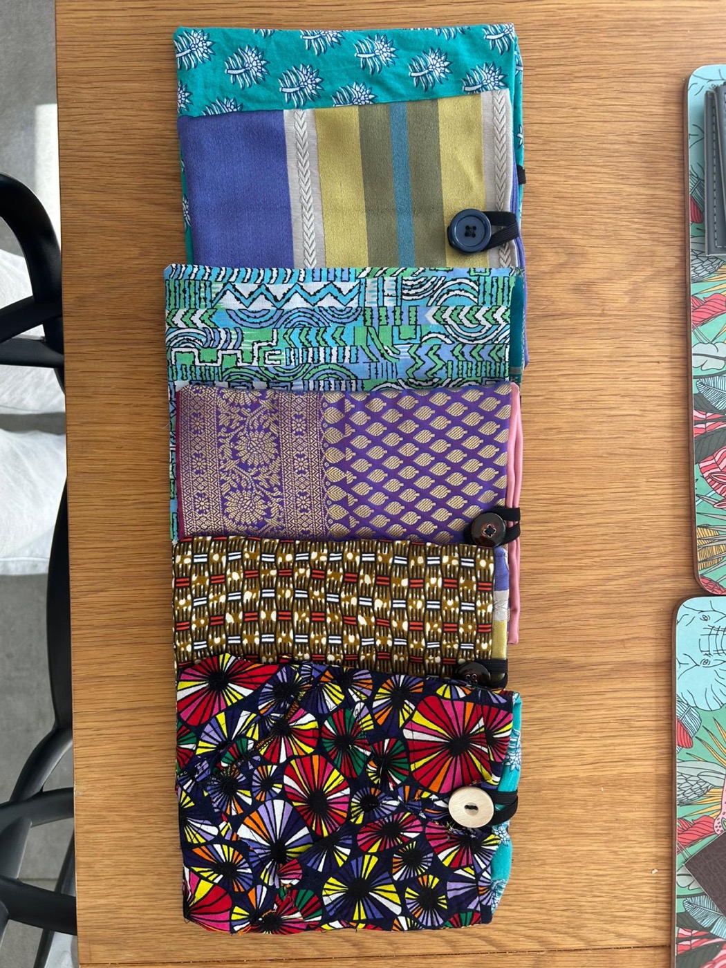 Five handcrafted Kindle cases made from different cultural fabrics