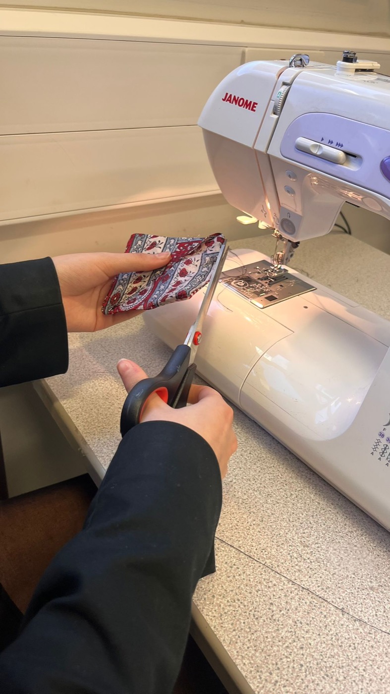 Trimming a finished bookmark next to the sewing machine